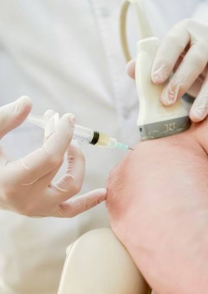 Doctor administering ultrasound-guided injection into patient’s elbow