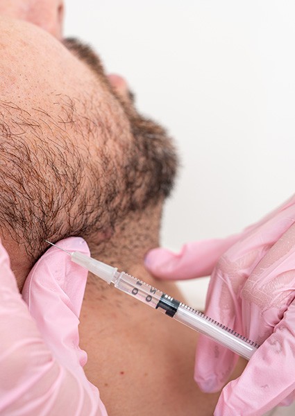 Man receiving injection in his jaw